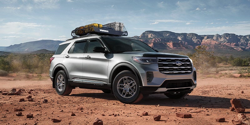 A Ford Explorer SUV parked in desert with mountains in background.